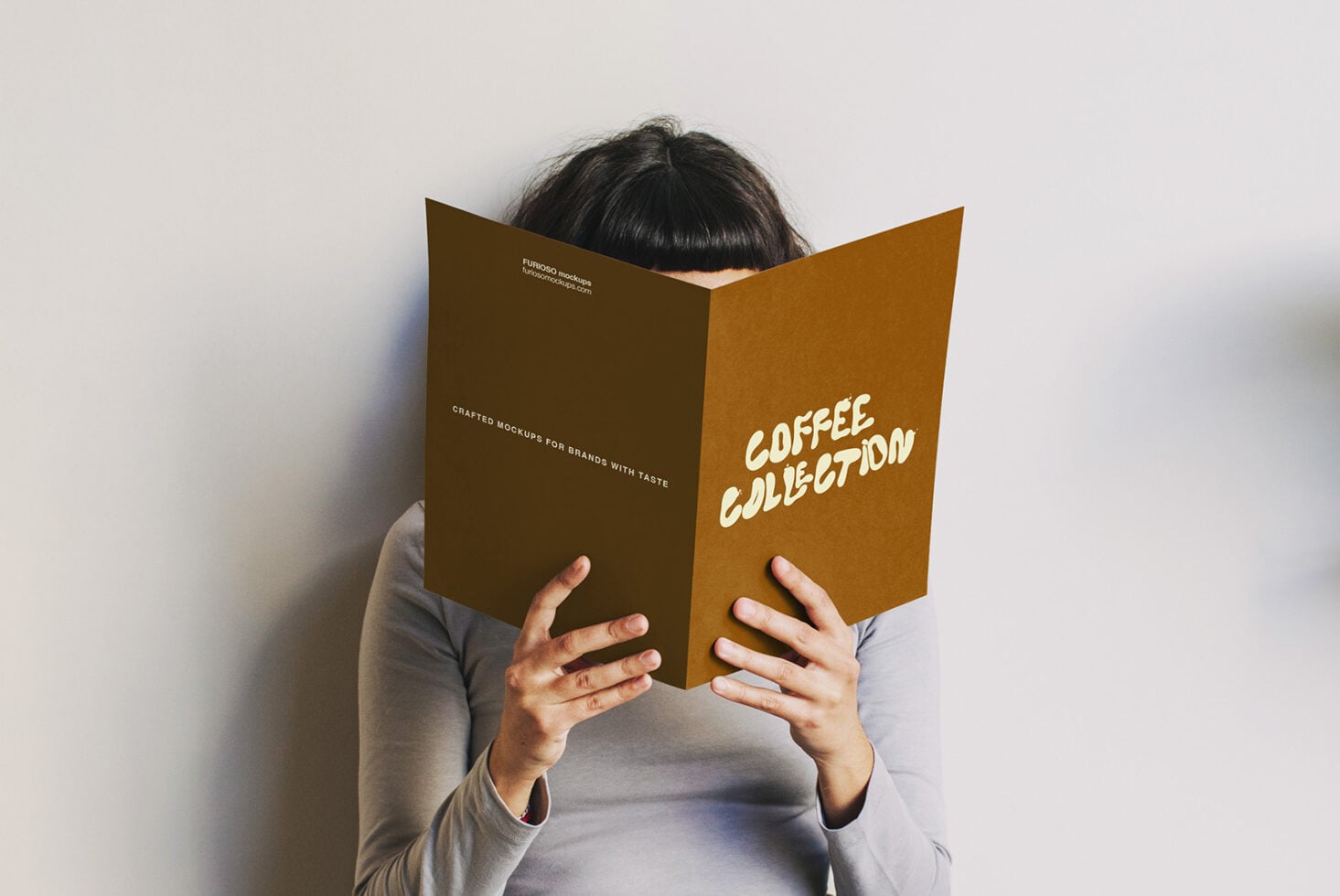 Person holding open brown folded brochure with Coffee Collection text visible