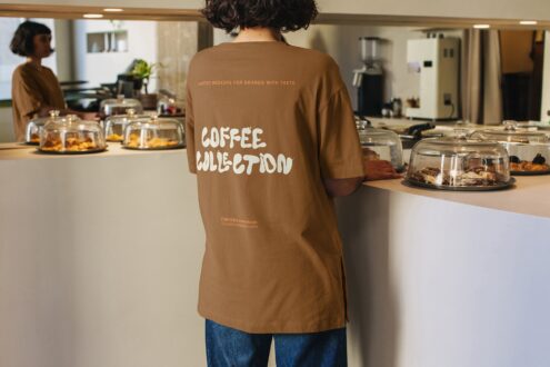 Brown crewneck shirt displaying coffee collection design indoors