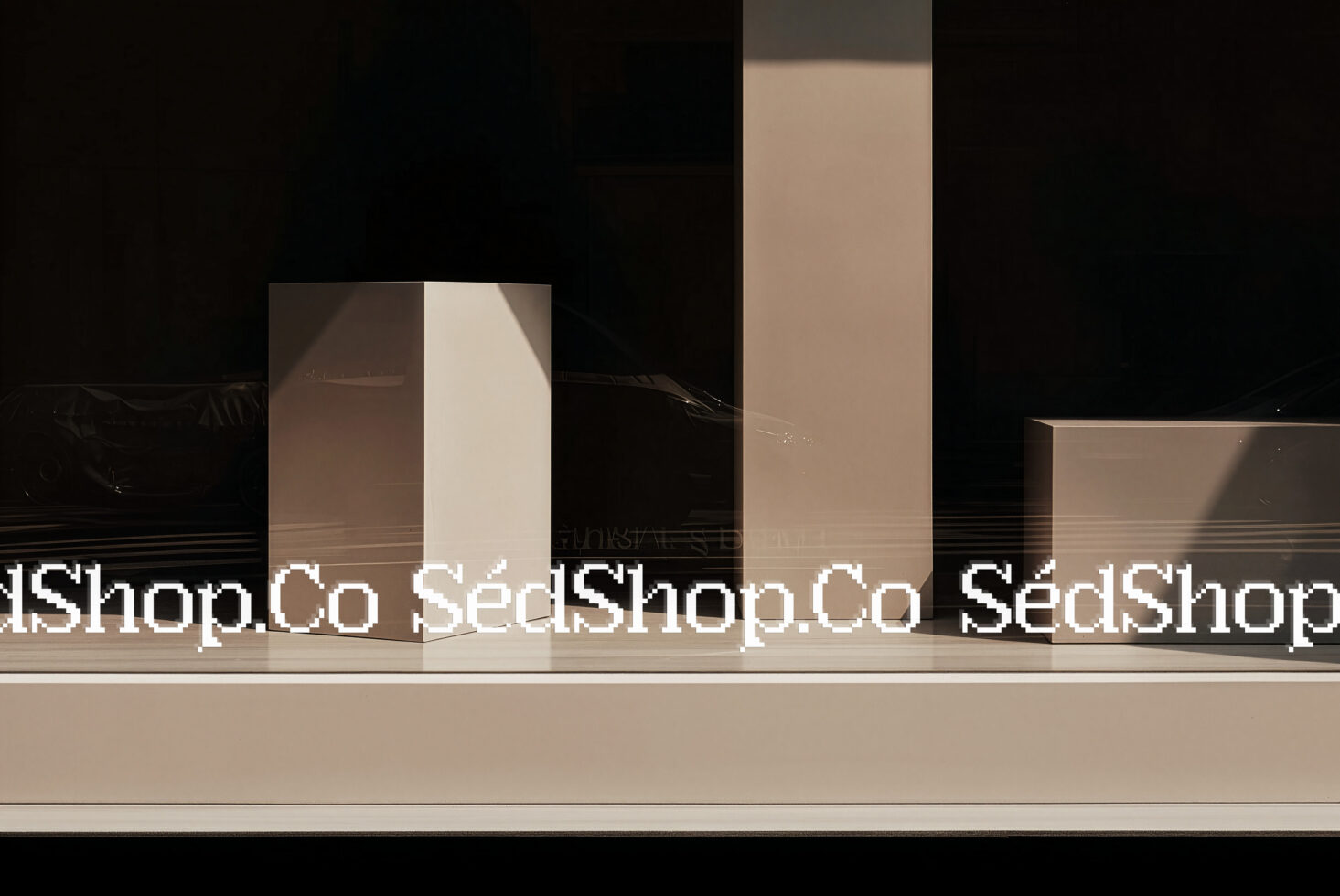 Storefront window display mockup with geometric boxes, natural light casting shadows, minimal aesthetic