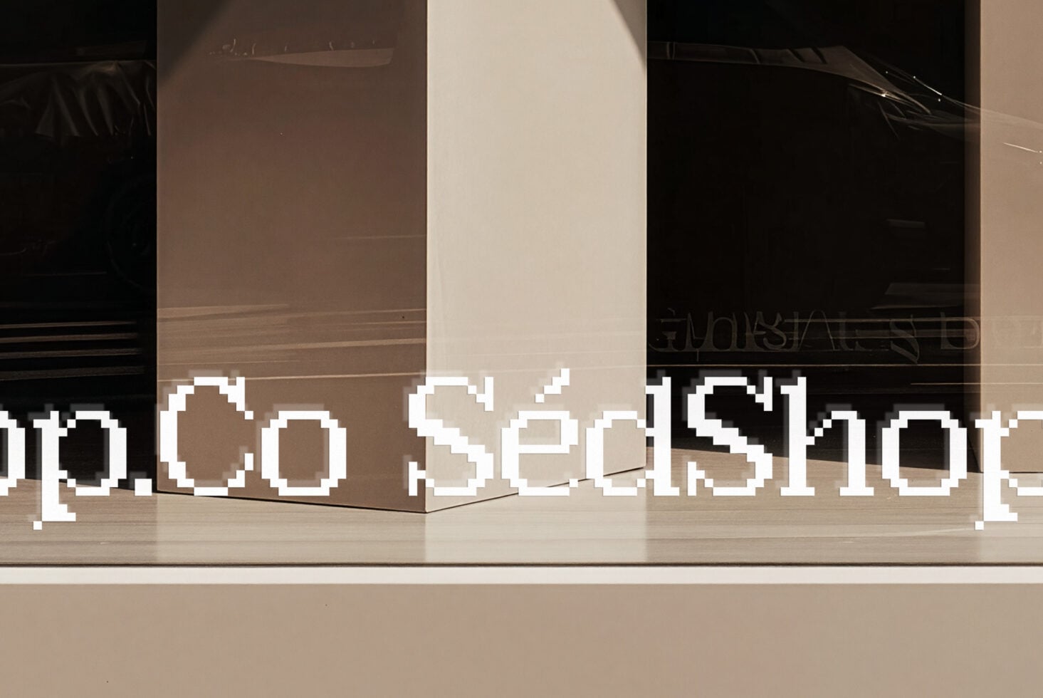 Pixelated white text overlaid on modern storefront window with neutral tones