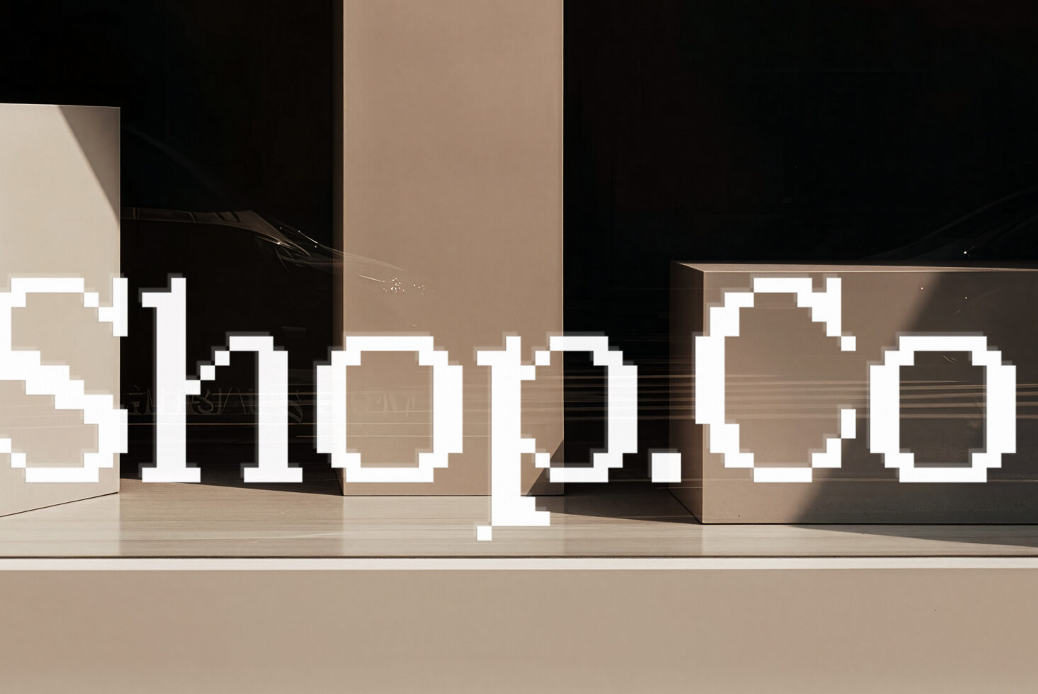 Pixelated 3D letters in white sitting on a modern beige stage with geometric boxes