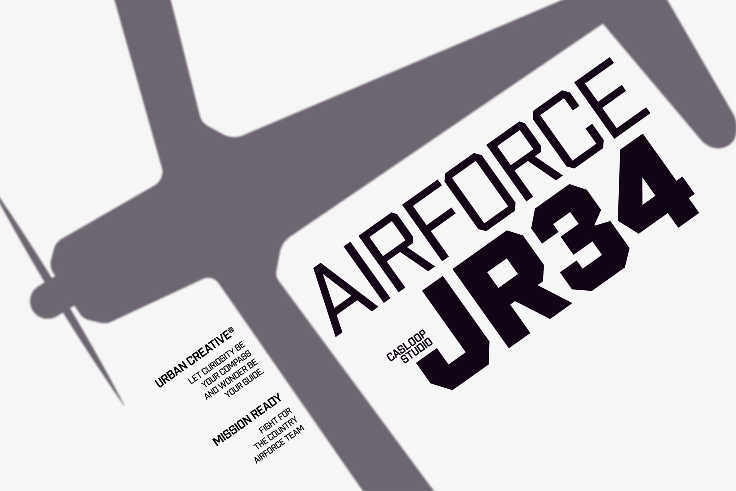 Close-up of bold black typography spelling "AIRFORCE" with mission statement text on white paper against gray geometric shapes
