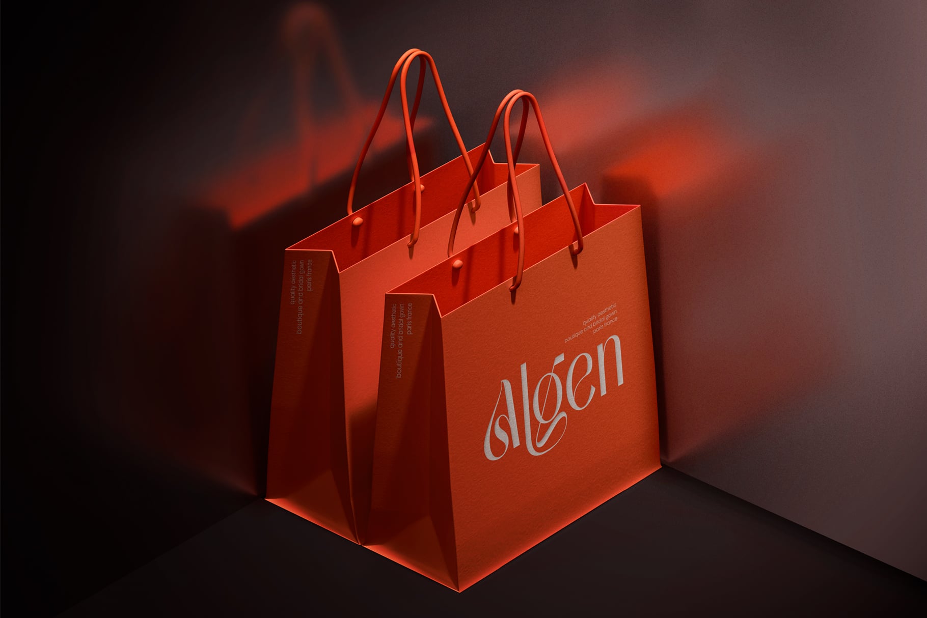 Bright red shopping bag mockup with rope handles, script logo on front, dramatic moody lighting