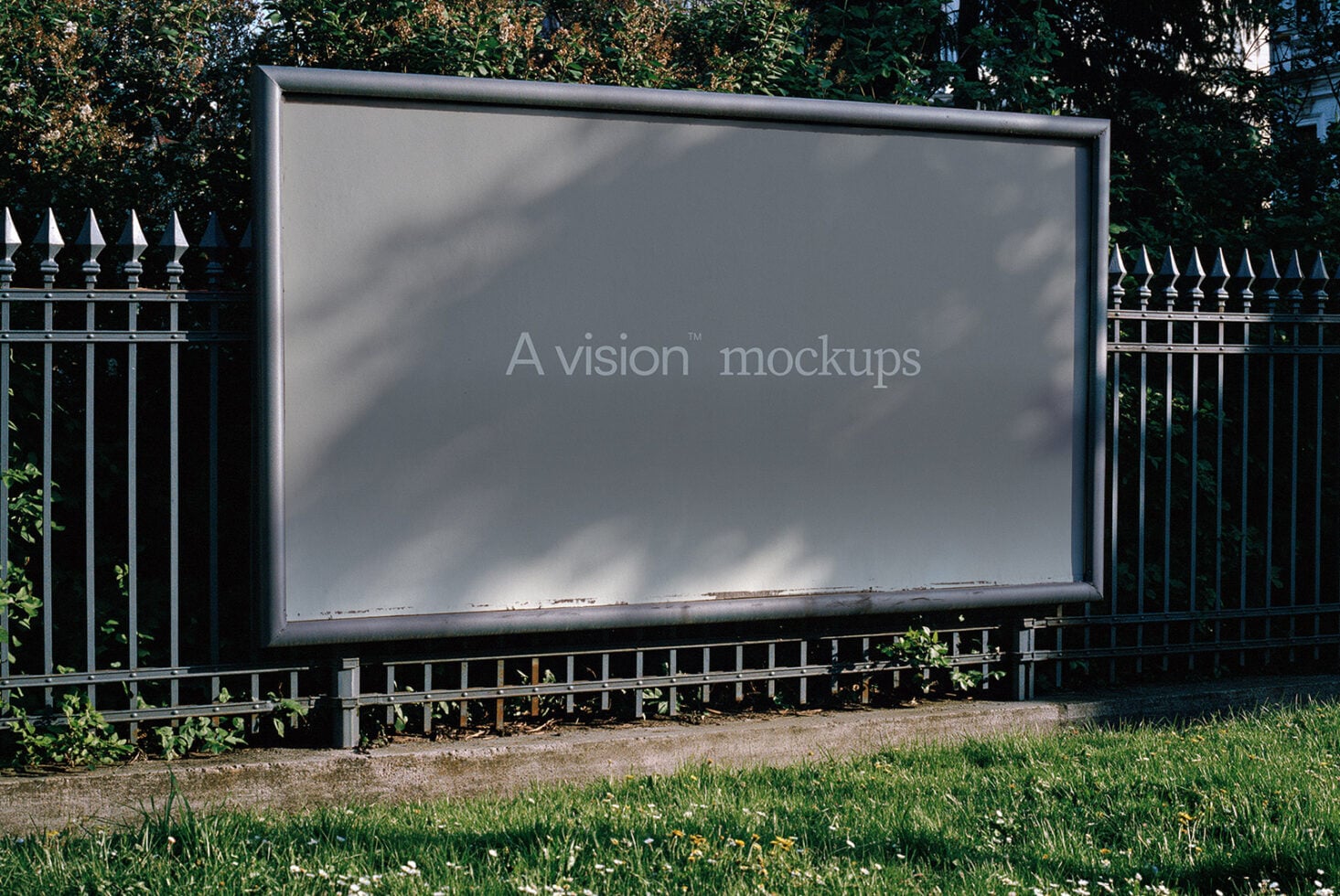 Outdoor billboard mockup with metal frame mounted on iron fence with ivy in background