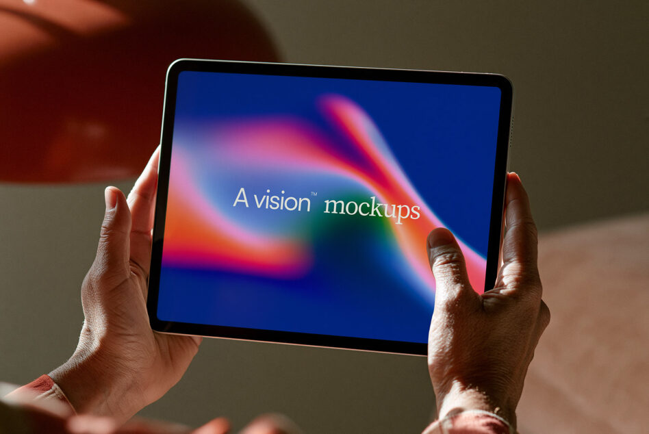 Hands holding tablet displaying colorful gradient with "A vision mockups" text centered on screen