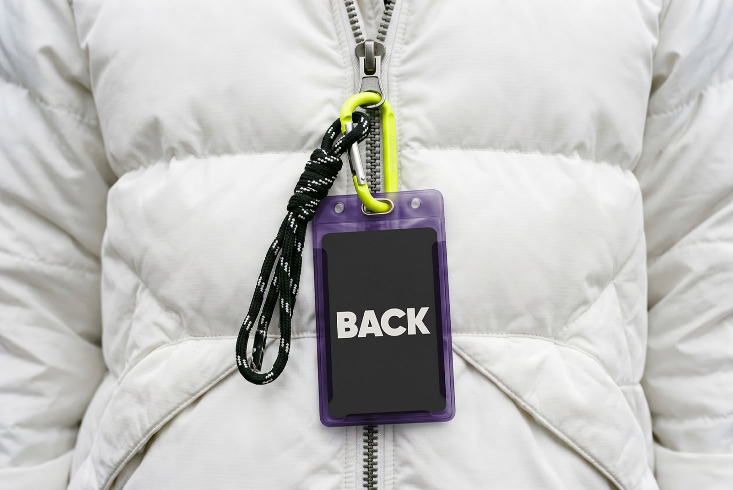 Purple ID badge mockup on white puffer jacket with neon carabiner lanyard