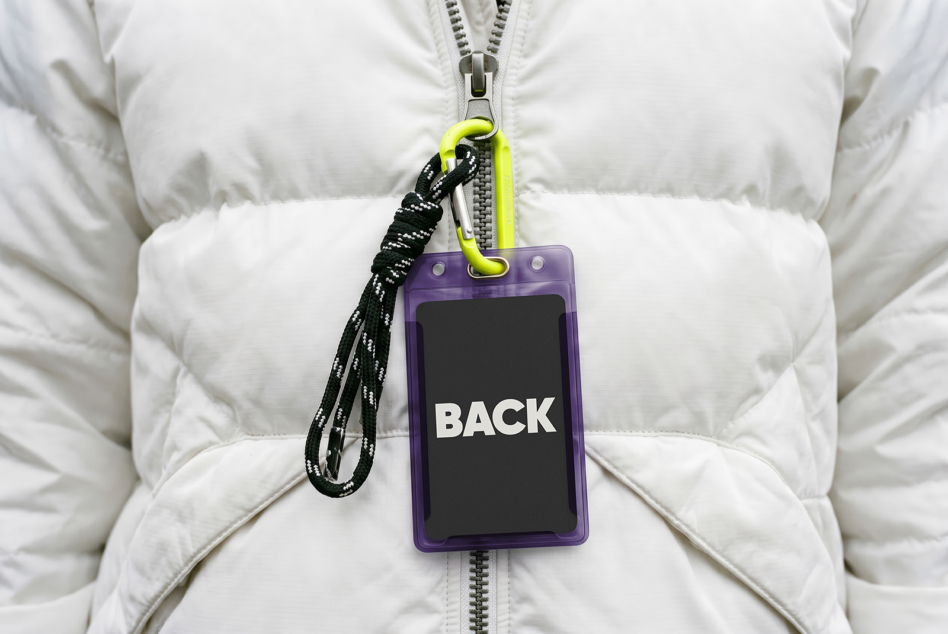 Purple ID badge mockup on white puffer jacket with neon carabiner lanyard