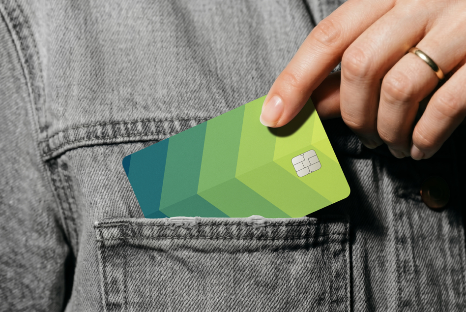 Hand pulling gradient credit card mockup from denim shirt pocket in sunlight