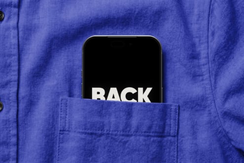 Smartphone in blue jacket pocket showing black screen with white BACK text
