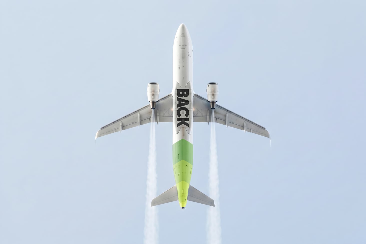 Overhead shot of white jet plane with lime green fuselage against clear sky