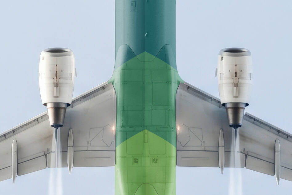 Symmetrical overhead shot of twin-engine plane with green fuselage against pale sky