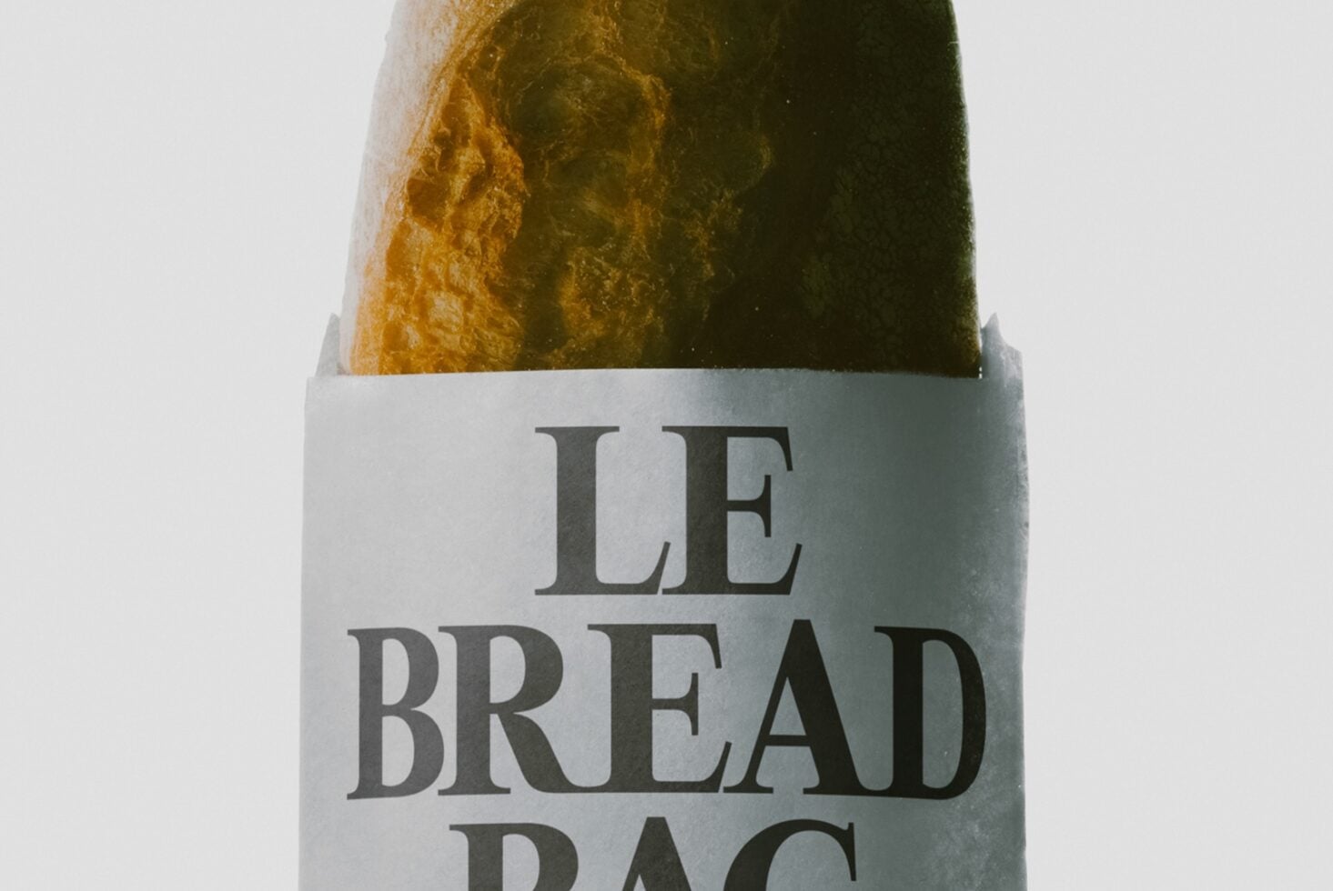 Le Bread Bag mockup showing crinkled paper wrapping with serif typography on loaf