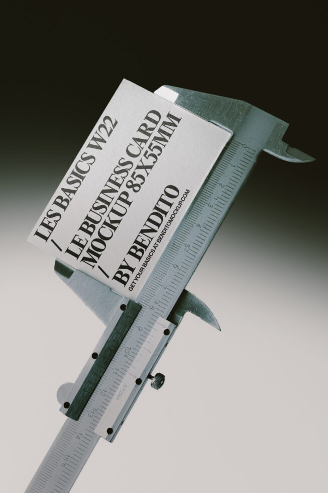 Business card mockup held in digital caliper measuring scale against white backdrop