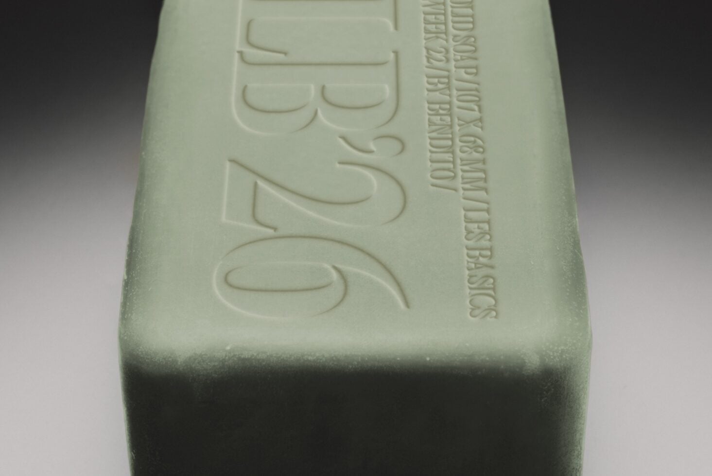 Embossed soap bar mockup with debossed text on pale green surface