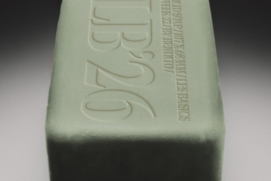 Embossed soap bar mockup with debossed text on pale green surface