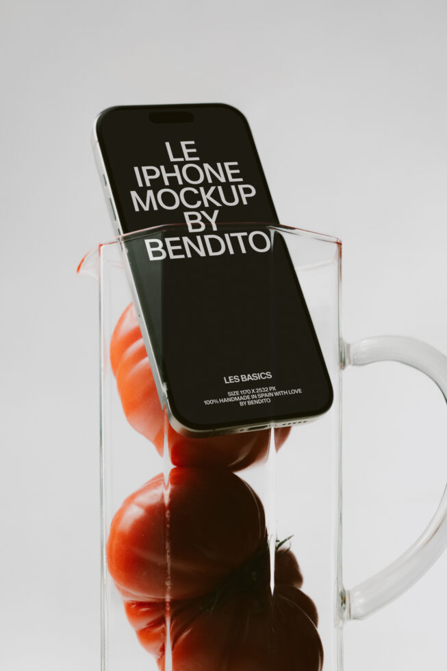iPhone mockup with black screen tilted in clear glass filled with red tomatoes