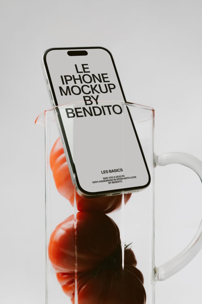 iPhone mockup leaning in clear glass with red flowers inside, clean minimal setup