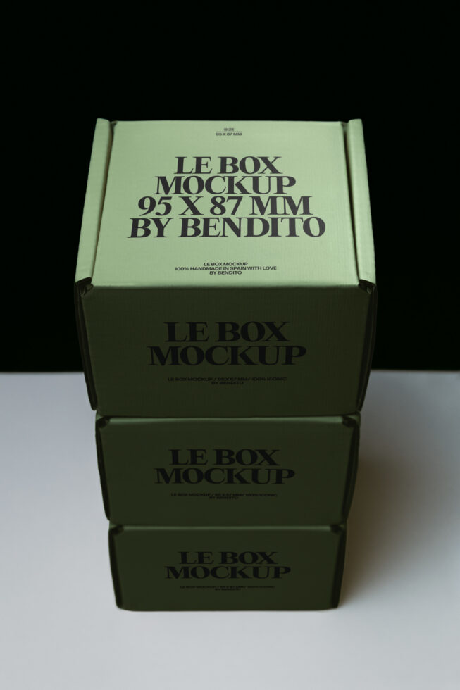 Stacked sage green shipping boxes with black text, top one open showing interior design space