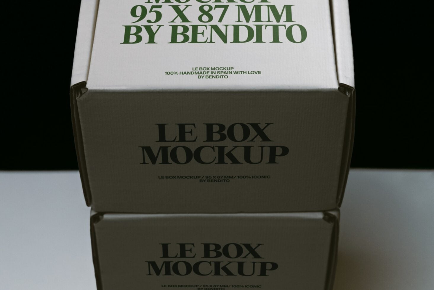 Stacked cardboard boxes with green serif typography showing mockup branding details