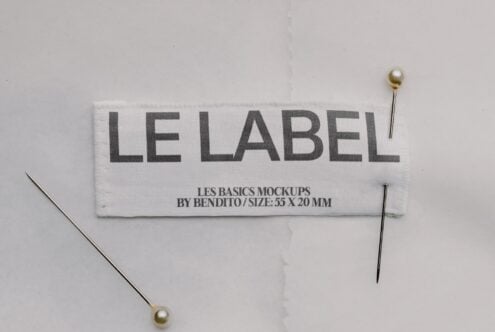 Woven label mockup with "LE LABEL" text, pinned down with pearl-headed pins on white background