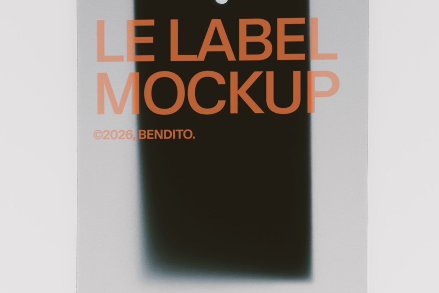 Hanging label mockup with orange text on black tag, blurred product background