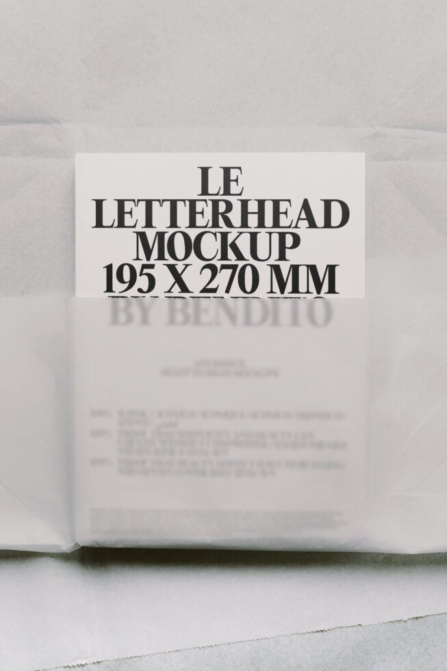 Cream letterhead mockup standing upright with bold serif typography on minimal concrete background