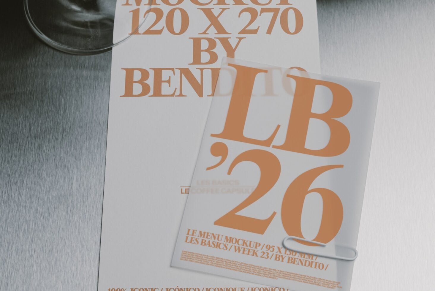 Stacked posters with bold orange typography on white paper, shot flat lay with dark bowl in corner on textured surface