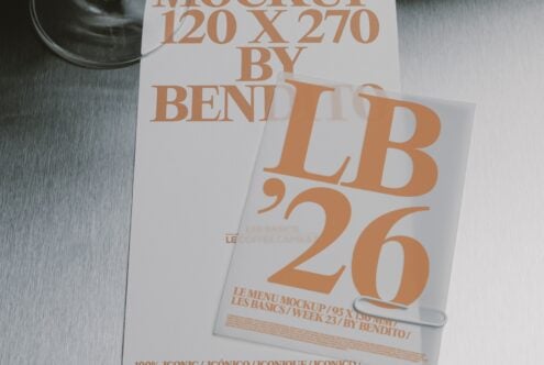 Stacked posters with bold orange typography on white paper, shot flat lay with dark bowl in corner on textured surface