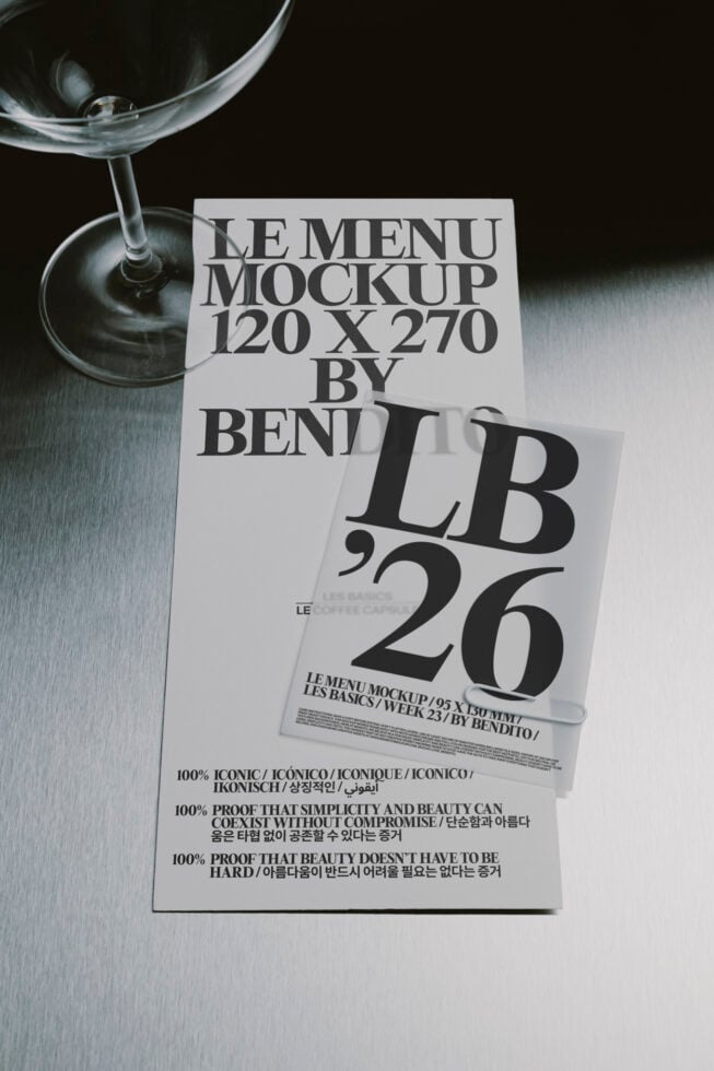 Martini glass next to layered menu mockups with bold serif typography on metallic surface