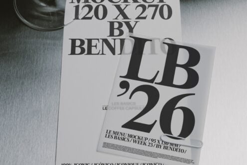 Stacked magazine covers with bold serif typography on brushed metal surface, cup visible top left