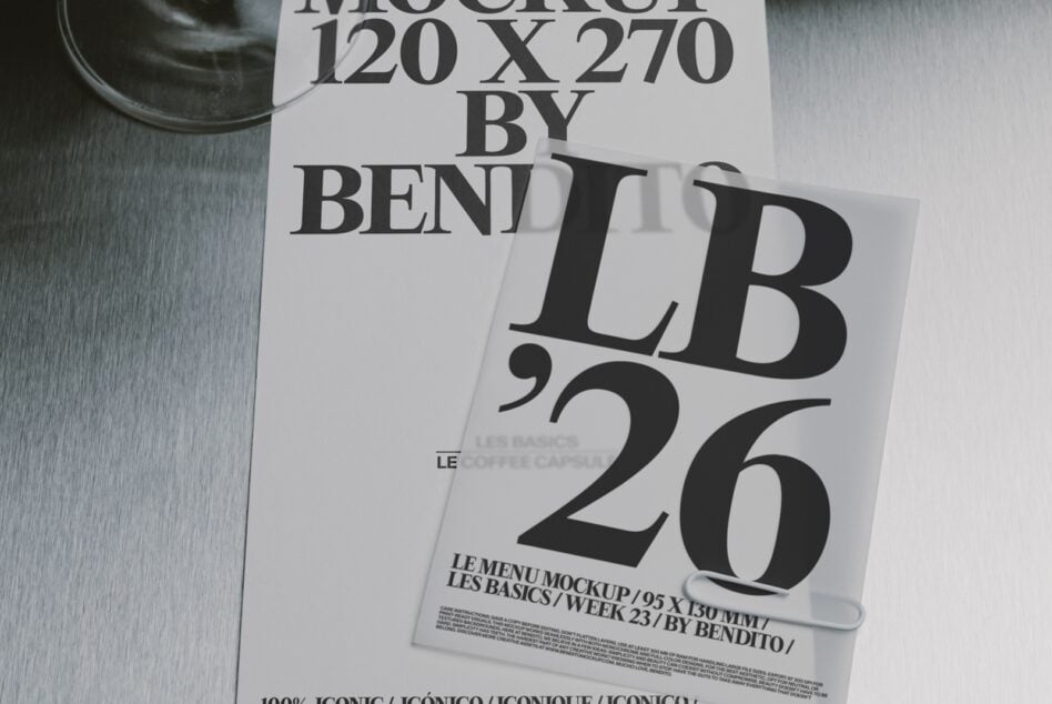 Stacked magazine covers with bold serif typography on brushed metal surface, cup visible top left