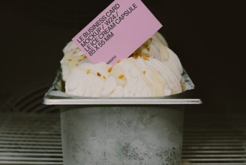 Pink business card mockup draped on ice cream cup with concrete texture