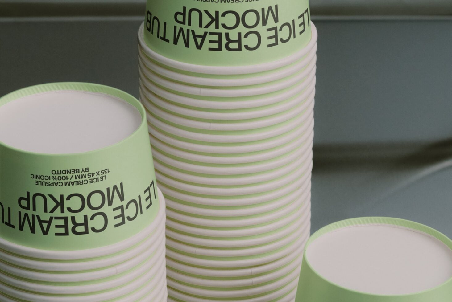 Stacked green striped paper cups with black text label showing packaging mockup
