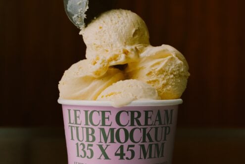 Vanilla ice cream scoops in pink tub with green text label on dark background