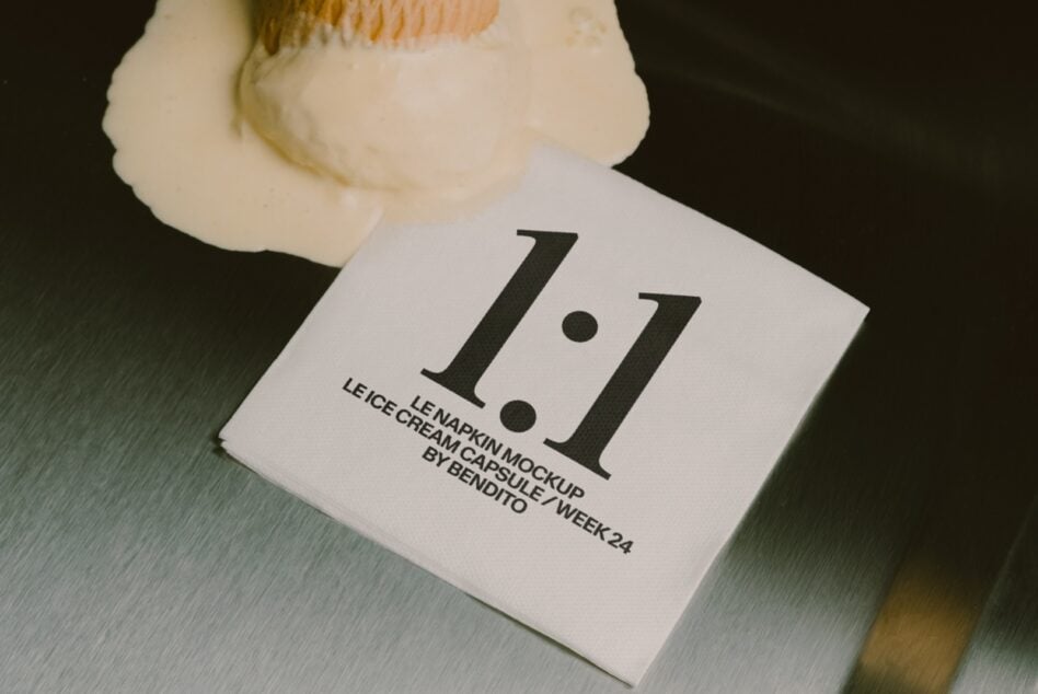 Leicester napkin mockup with cream capsule showing bold serif numbers on brushed metal surface