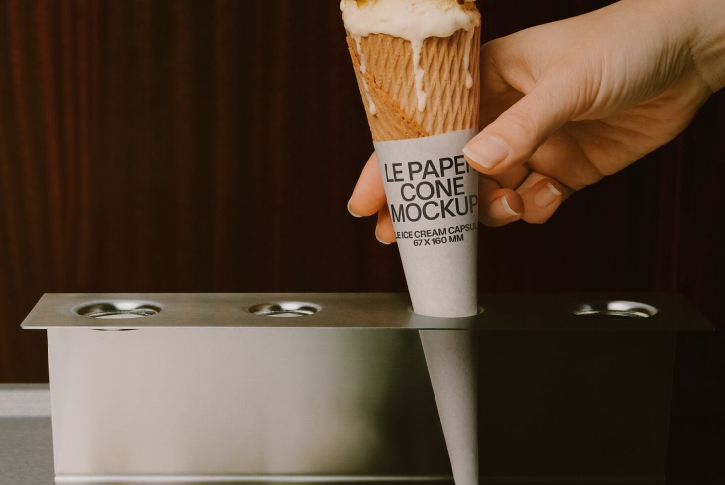 Hand holding ice cream cone with paper wrapper mockup over cup