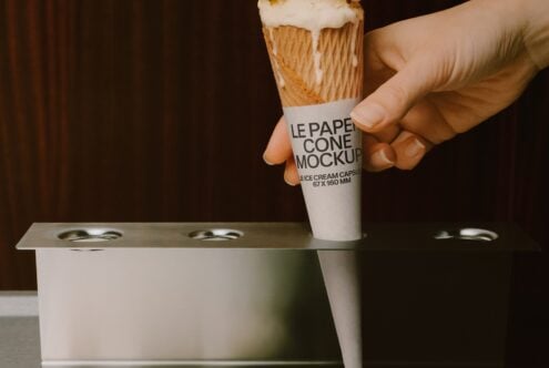 Hand holding ice cream cone with paper wrapper mockup over cup