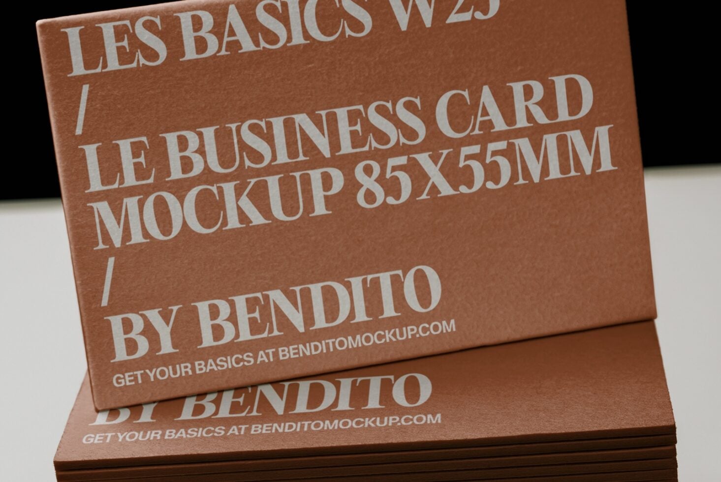 Stacked business cards in warm tan cardstock with modern sans serif typography, angled view showing depth