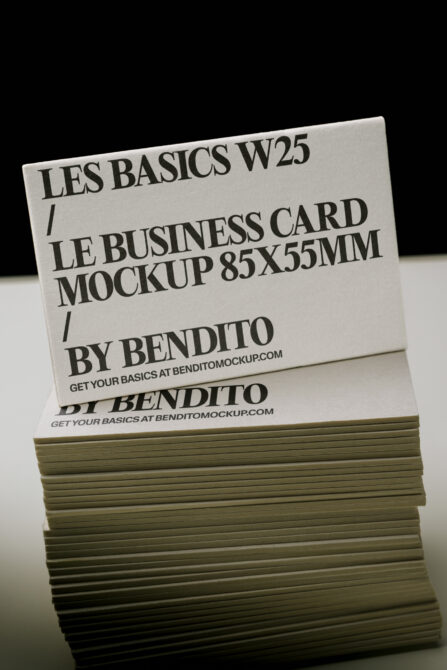 Stacked business cards with bold serif typography showing "Les Basics W25" mockup branding on cream stock with olive green edges