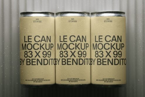 Three condensation-covered beverage cans with cream labels, black typography, metallic tops on gray background