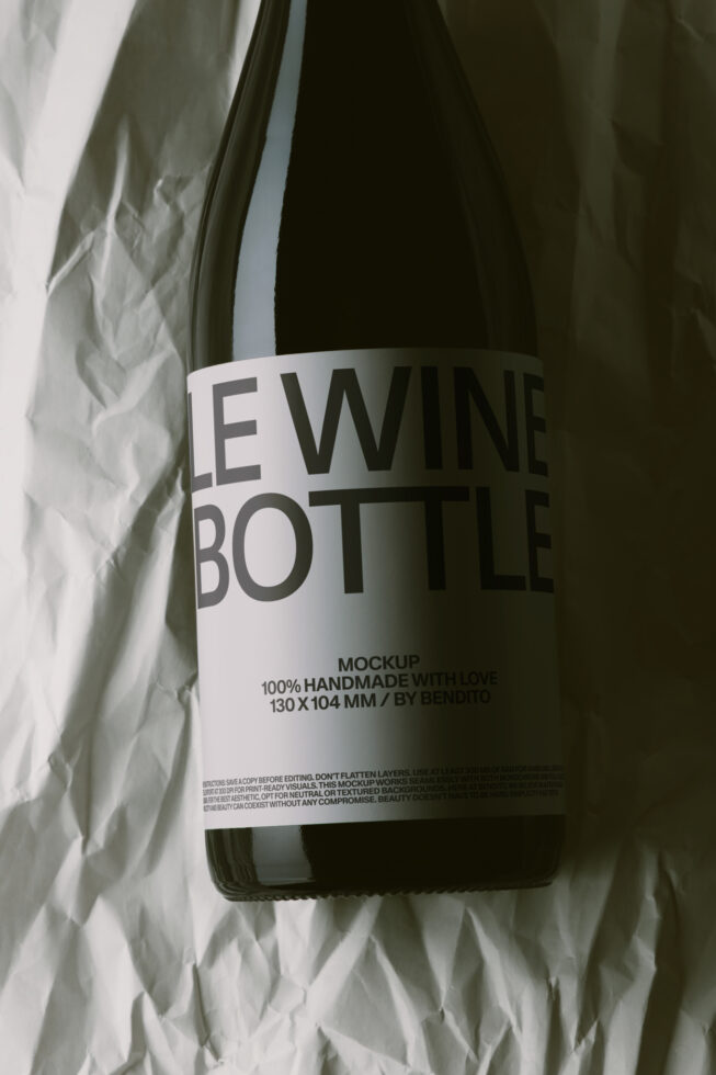 Wine bottle mockup with white label showing typography on crumpled paper background