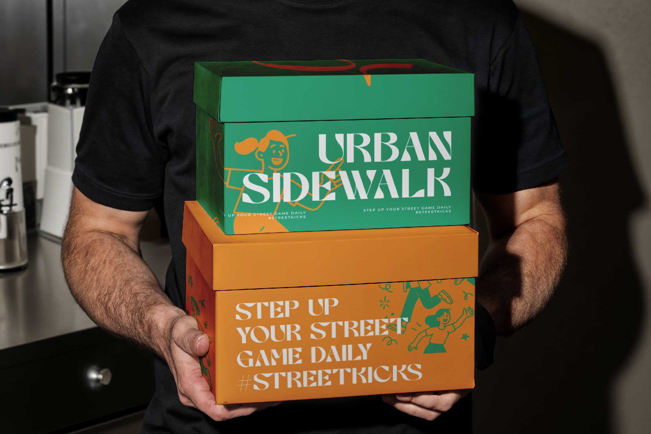 Person holding stacked green, orange boxes with Urban Sidewalk branding, street tricks tagline visible