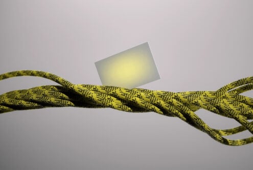 Frosted glass card mockup balancing on twisted yellow climbing rope against soft gray backdrop