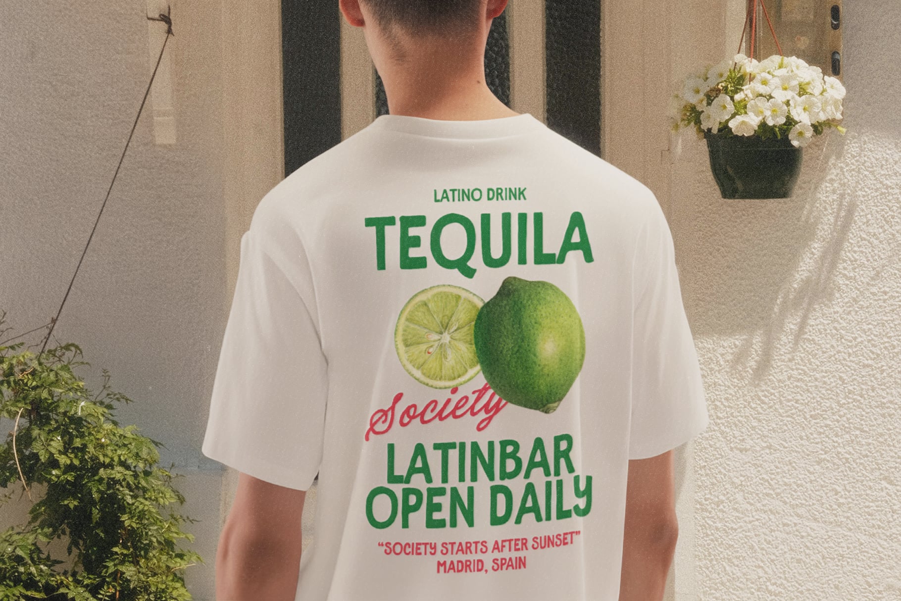 Back view of cream tee with tequila lime graphic, green bold text, red script accents