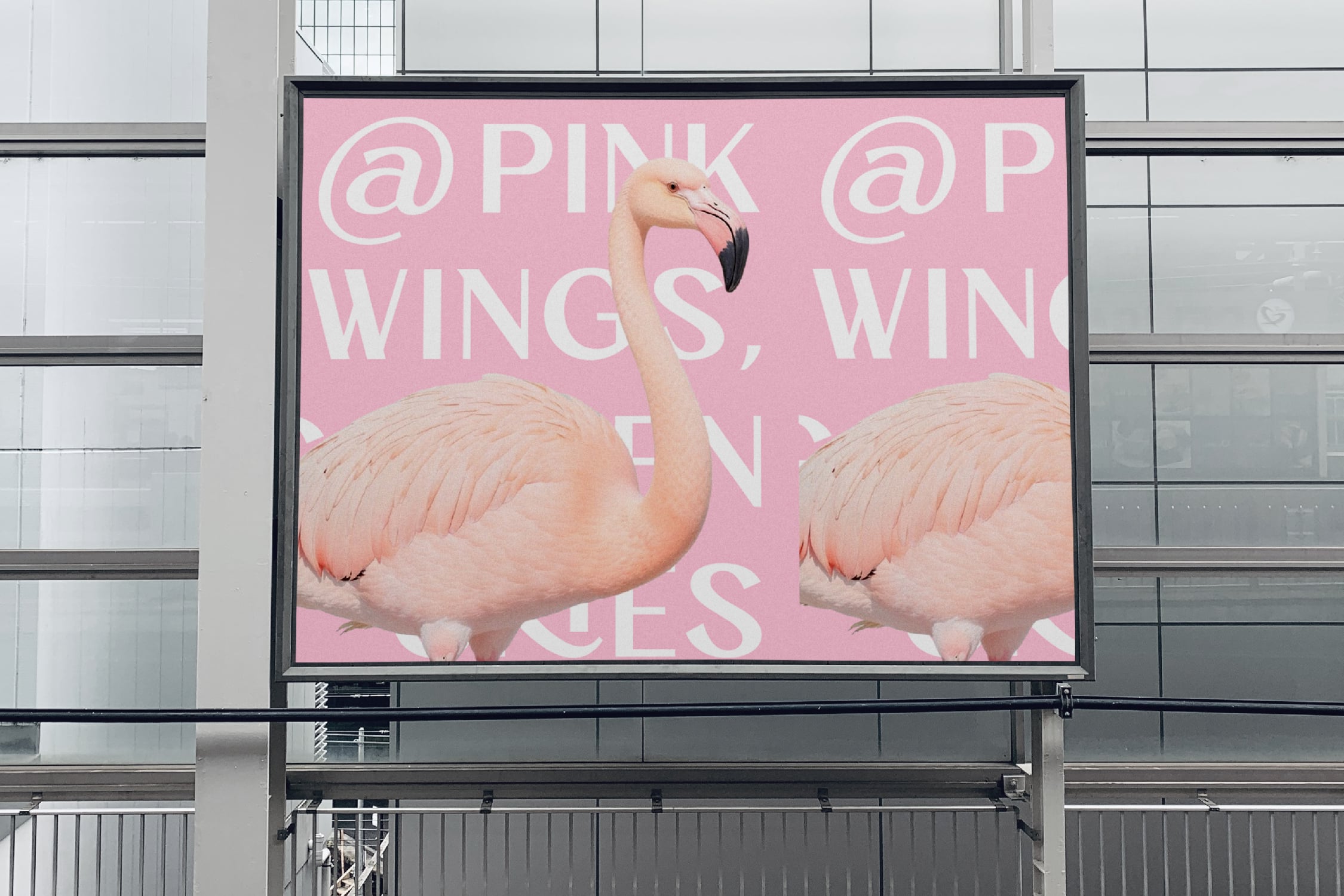Pink billboard mockup with flamingos displaying playful text on urban building facade
