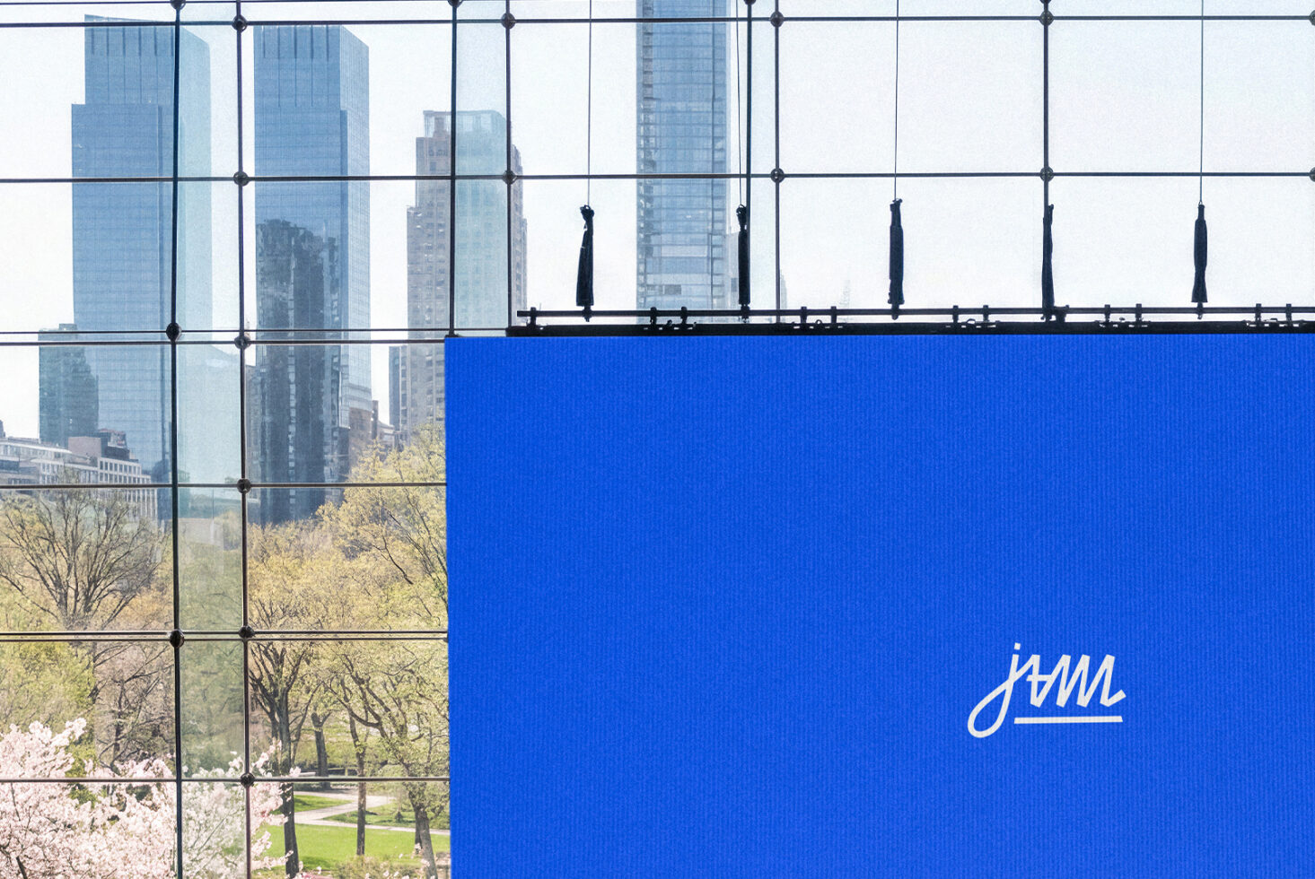 Rooftop terrace overlooking city skyline with bright blue banner displaying script logo