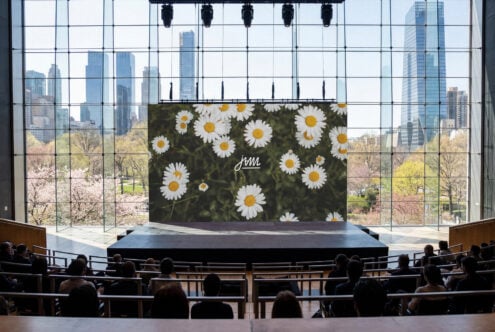 Billboard mockup with daisy flowers on dark background, skyline view behind