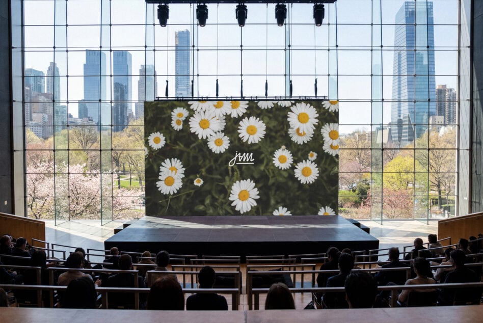 Billboard mockup with daisy flowers on dark background, skyline view behind
