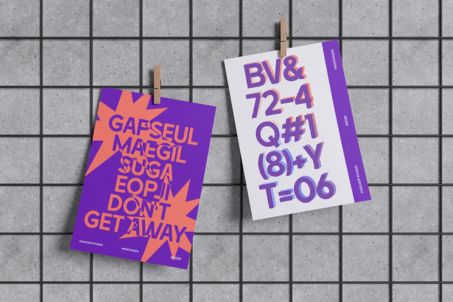 Two bold posters clipped to wooden pegs showing vibrant purple, orange, pink typography on concrete tile background