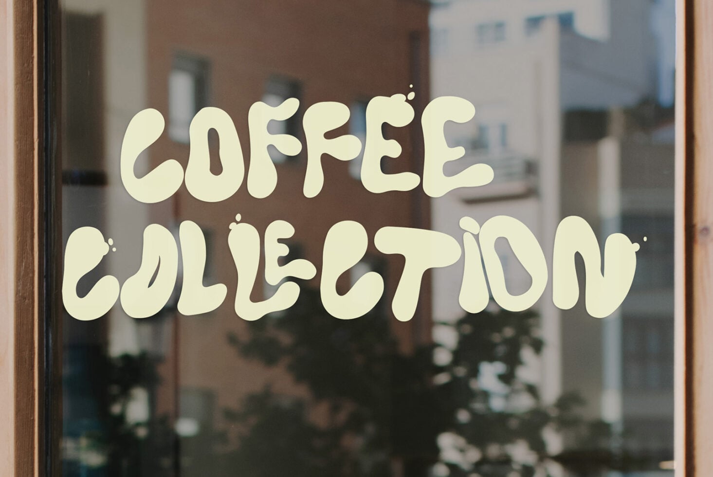Coffee collection window decal with cream wavy lettering on glass storefront